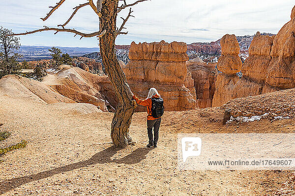 United States  Utah  Bryce Canyon National Park  Rear view of senior female hiker with backpack looking at view in Bryce Canyon National Park