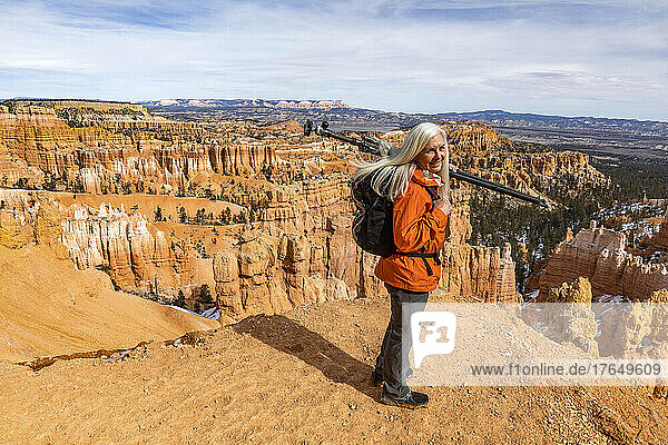 United States  Utah  Bryce Canyon National Park  Senior female hiker with backpack and tripod in Bryce Canyon National Park