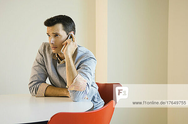 Man sitting at table using mobile phone