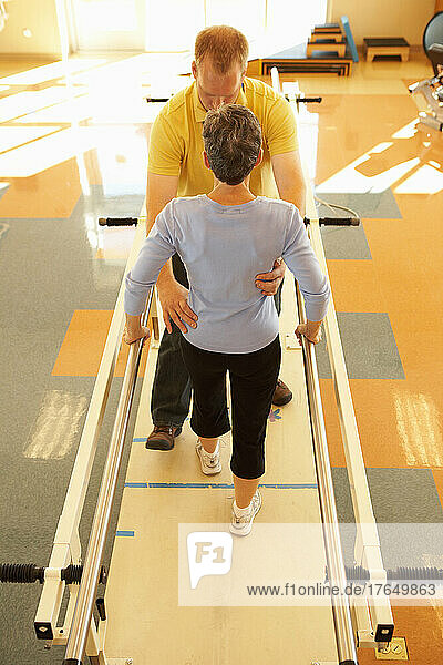 Physical therapist with patient in gym