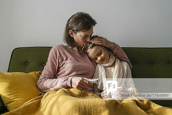 Mother embracing sick daughter at home