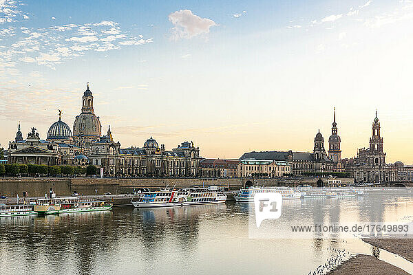 Germany  Saxony  Dresden  Elbe river at dusk with moored tourboats and Dresden Academy of Fine Arts in background