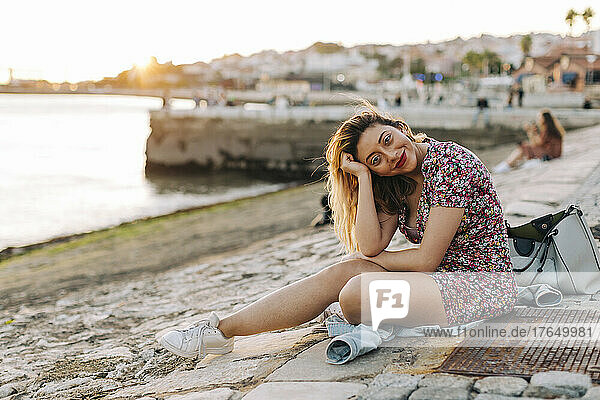 Smiling woman sitting at seashore