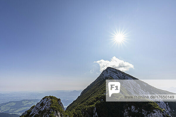 Scenic view of mountain peaks under blue sky on sunny day