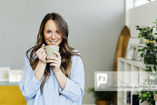Smiling beautiful woman with coffee cup at home
