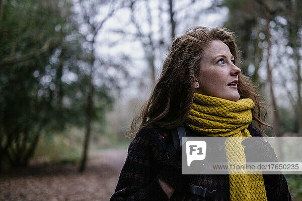 Junge Frau mit gelbem Schal im Wald