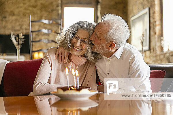 Glücklicher älterer Mann umarmt Frau  die Geburtstag im Boutique-Hotel feiert