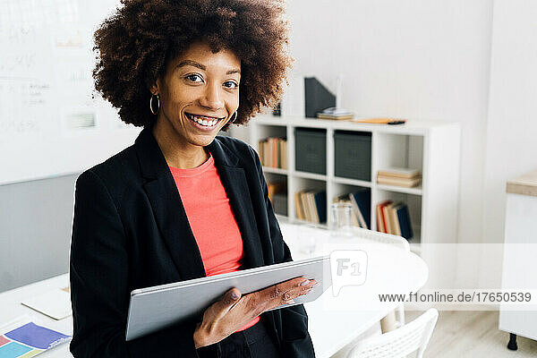 Smiling businesswoman with tablet PC in office