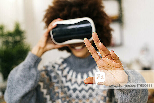 Woman gesturing with virtual reality simulator at home
