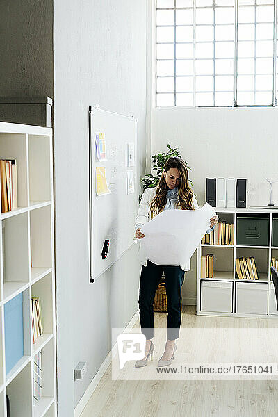 Businesswoman analyzing business plan at office