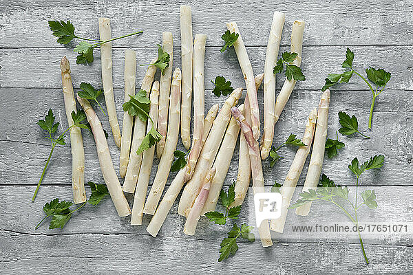 Studio shot of parsley and peeled asparagus stalks