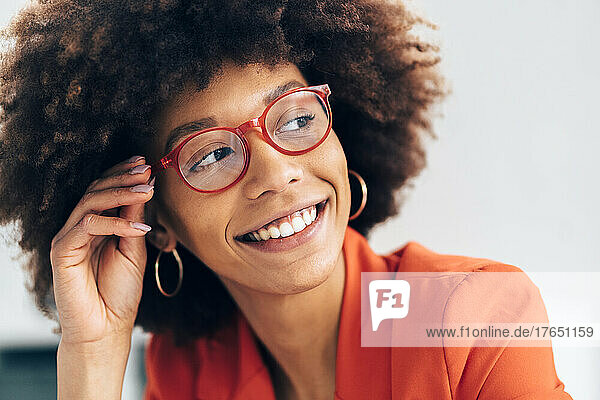 Smiling businesswoman with Afro hairstyle wearing eyeglasses