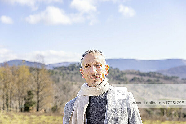 Man with scarf and jacket on sunny day