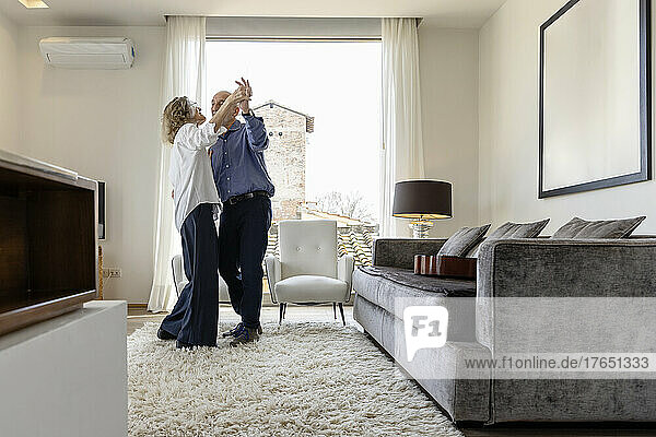 Älteres Paar tanzt zu Hause im Wohnzimmer