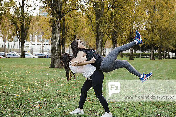 Woman piggybacking her sister in public park