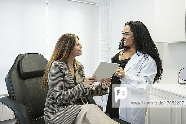 Doctor discussing over tablet PC with patient at clinic