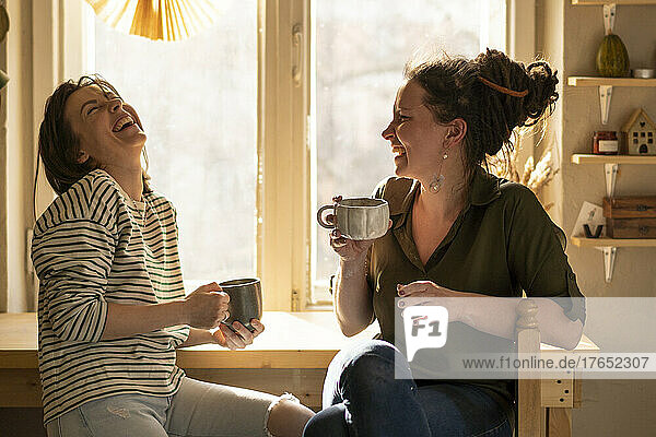 Cheerful coworkers enjoying coffee break at workshop