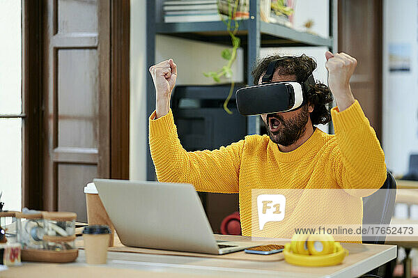 Businessman with mouth open wearing virtual reality simulator in office