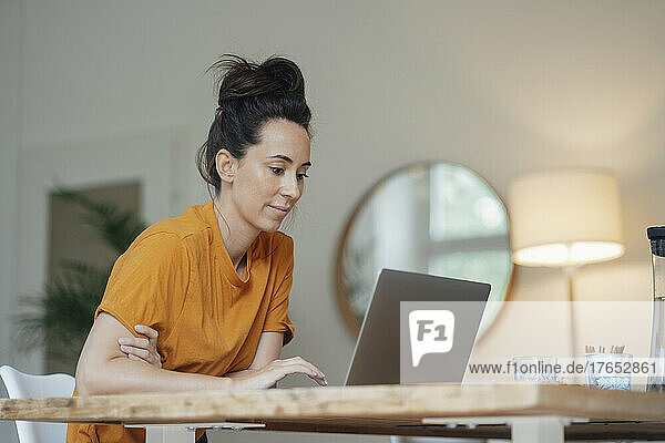 Woman using laptop in living room at home