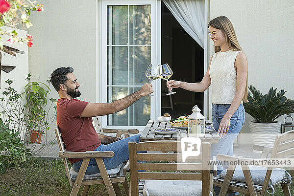 Smiling couple toasting wineglasses in garden