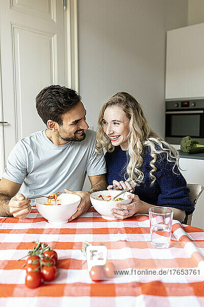 Romantic couple having food on dining table at home