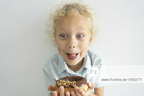 Happy blond girl enjoying doughnut
