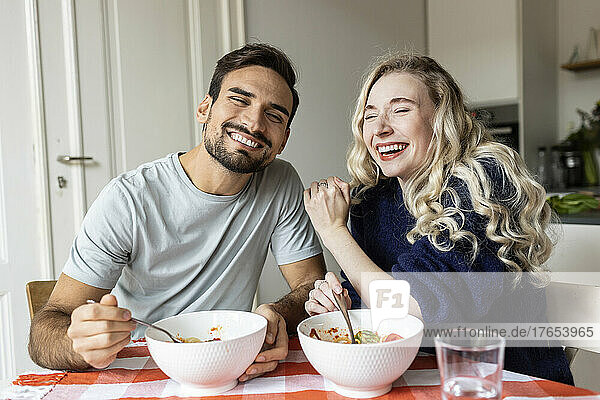 Happy couple enjoying meal at home