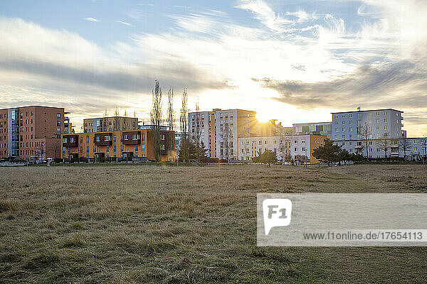 Buildings in front of agricultural field on sunny day