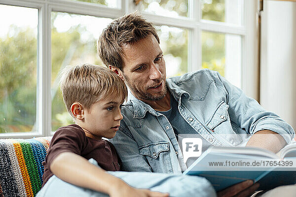 Father reading book to son at home