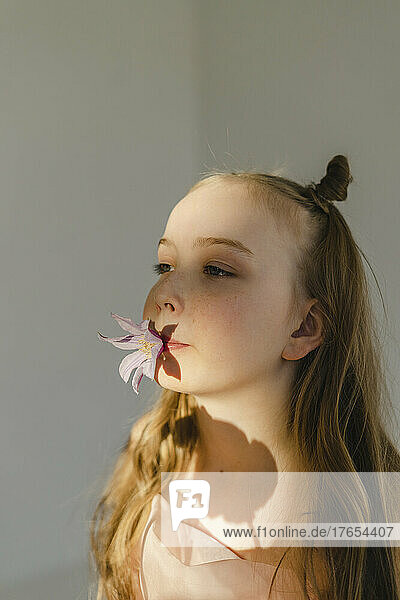 Girl holding flower in mouth