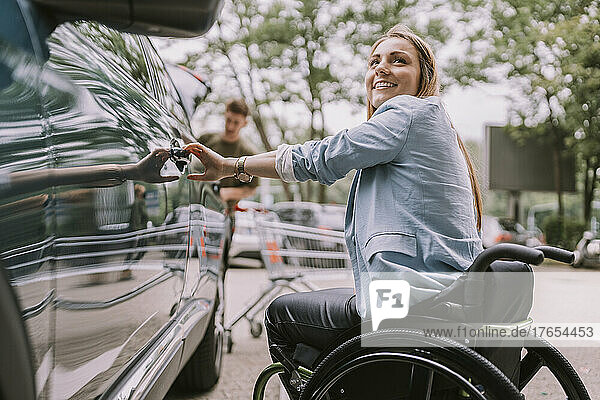 Happy disabled woman opening car door