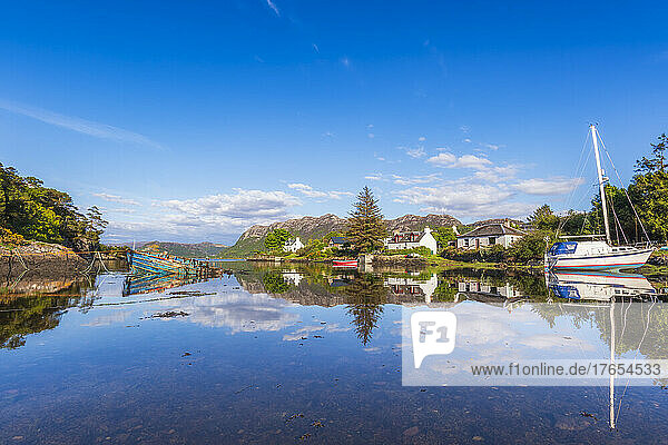 Picturesque Plockton village and boat reflecting on lake  Scotland