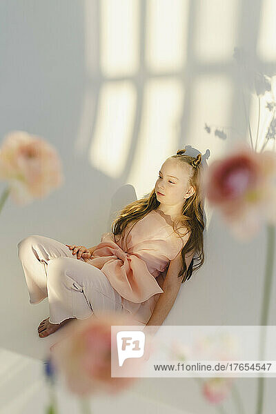 Girl lying down in front of white wall