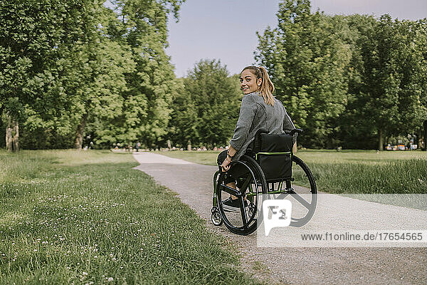 Young woman sitting in wheelchair at park