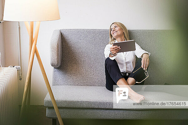 Smiling businesswoman with tablet computer in office