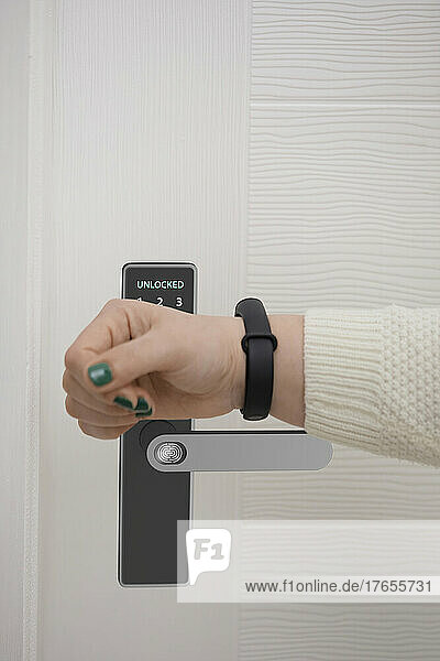Woman opening door with access to smart watch