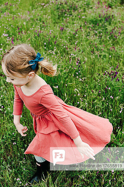 young girl running in a field of spring flowers