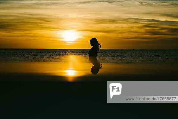 Silhouette of girl in golden sunset over east chine sea