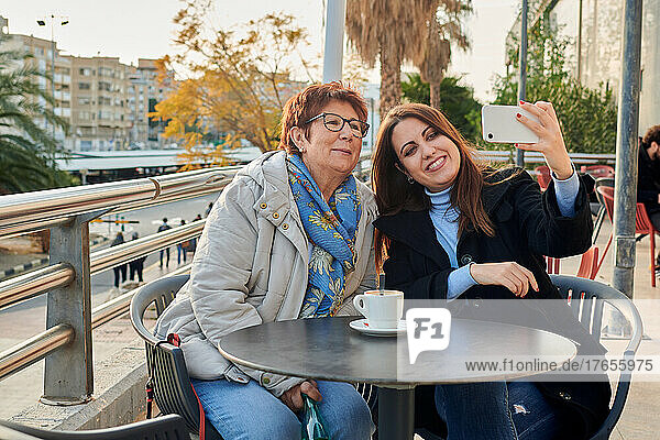Mature woman and young woman take a selfie with their phone