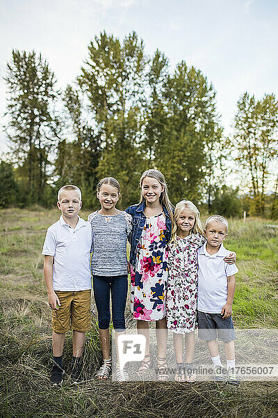 Outdoor portrait of five siblings  two boys  three girls.