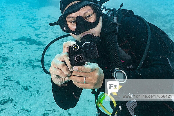 diver taking picture with a waterproof action cam