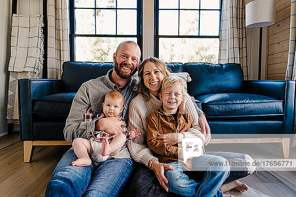 Family of four smiles at camera while sitting in cabin on sunny day