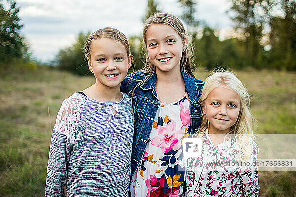 Outdoor portrait of three beautiful young girls  sisters .