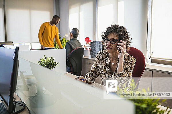 Senior woman talking on the phone working in an office.