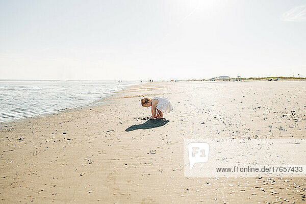 Girl plays in the sand along the South Carolina coastline