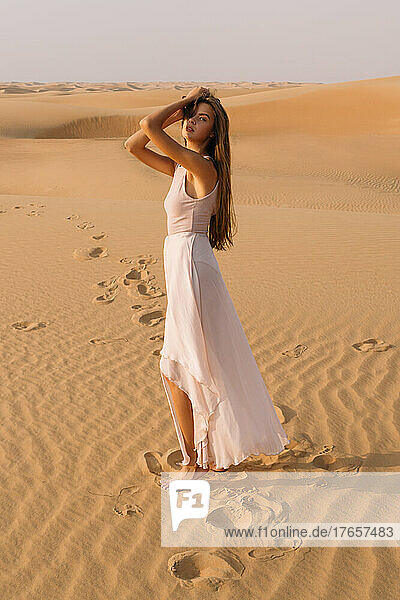 Girl posing in the sand in the desert