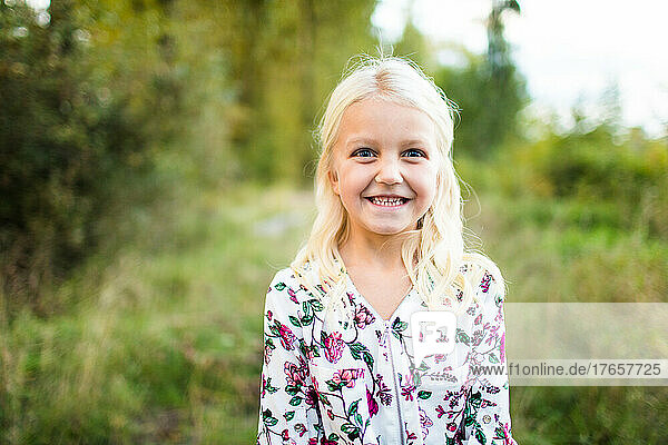 Cute young blonde girl with a huge smile on her face.