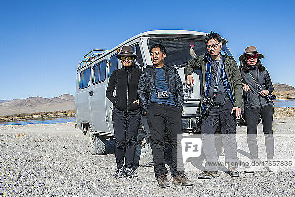 group of friends posing in front of their rugged 4x4 van