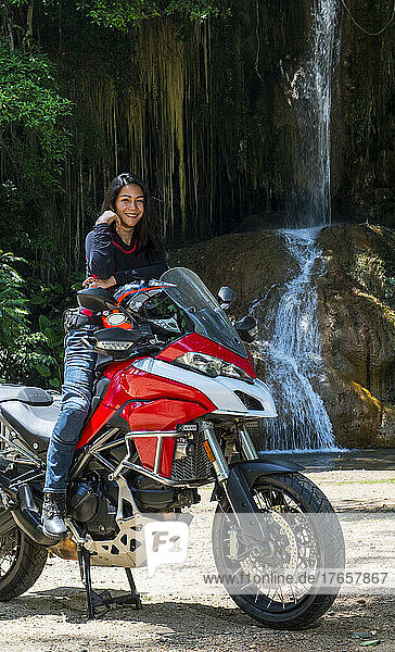 Thai woman resting on her adventure motorcycle in north Thailand