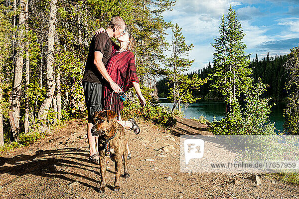 Young couple going for a swim with their dog a lake